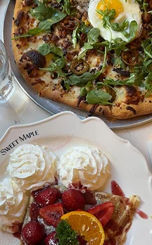 Pizza and a waffle with cream and strawberries at brunch
