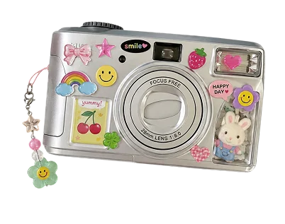 A silver point-and-shoot camera covered in cute stickers