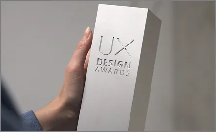 Holding a UX Design Award trophy